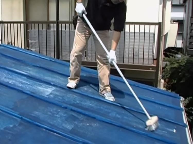 長柄ワイヤーブラシを使ったトタン屋根のケレン作業