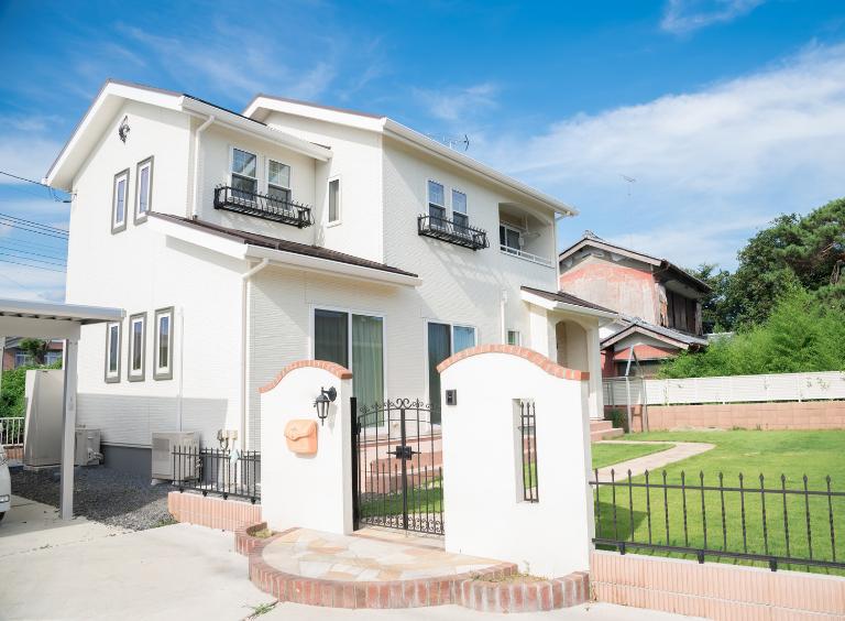 玄関や塀、外構のコンクリート部分がおしゃれに塗装された家